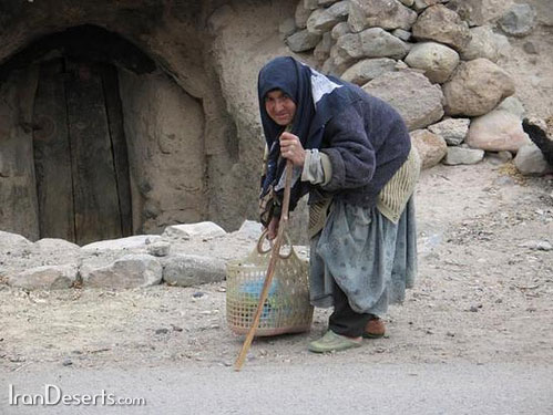 پیر زن میمندی جلو درب منزل مسکونی خود ایستاده 
